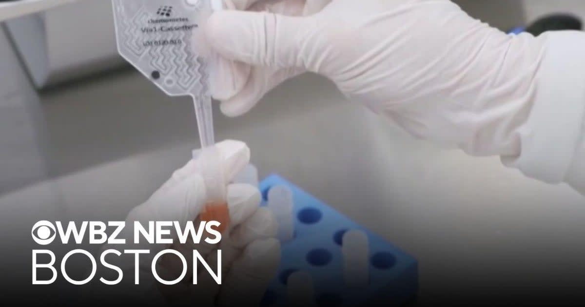 Medical researchers examining cancer cells under microscope in modern laboratory setting