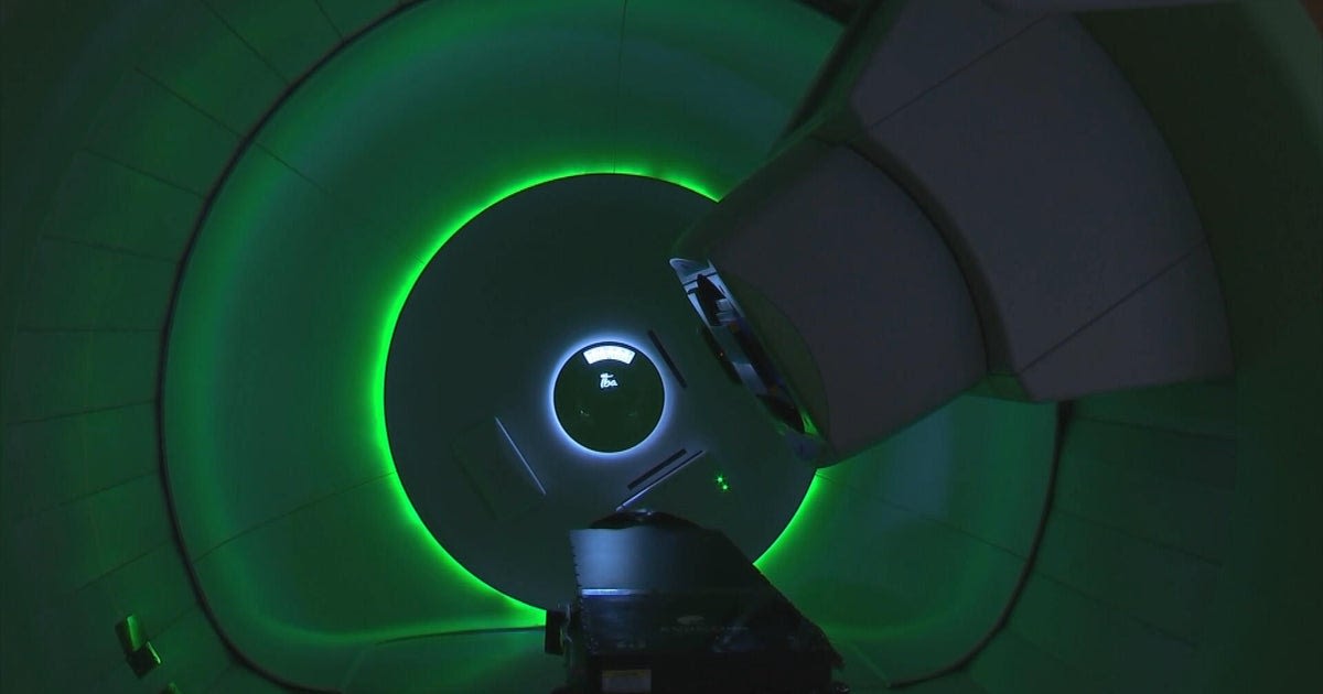 Doctor examining advanced proton therapy equipment at Penn Medicine cancer treatment facility