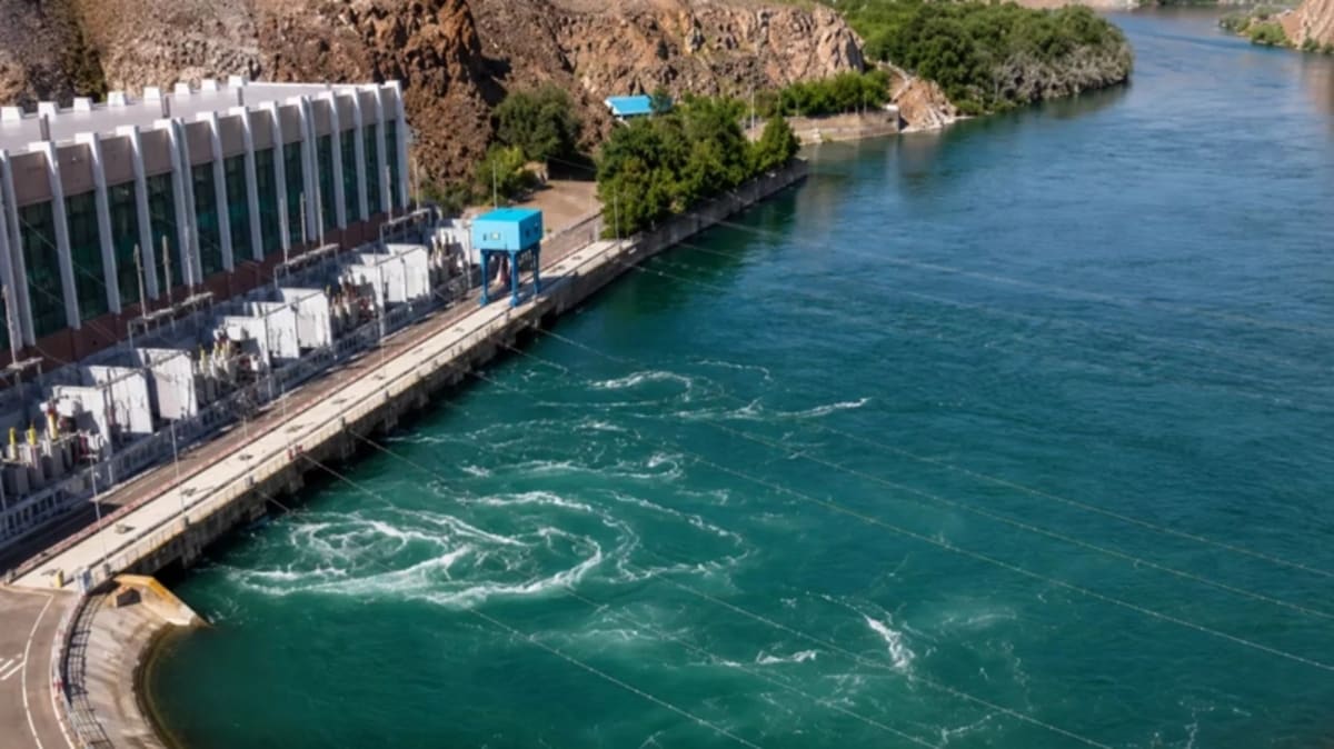 Hydroelectric dam in Kazakhstan with water flowing through turbines generating clean renewable power