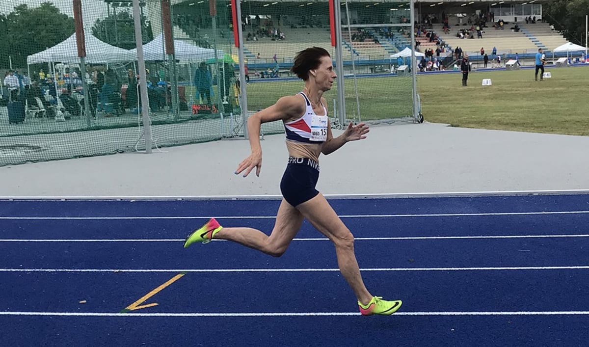 72-year-old Caroline Powell sprinting on outdoor track at masters athletics competition