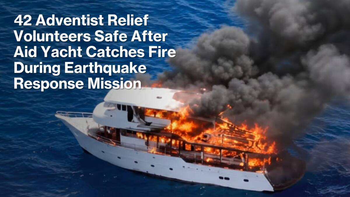 Relief volunteers evacuating burning yacht onto rescue boats off Philippine coast
