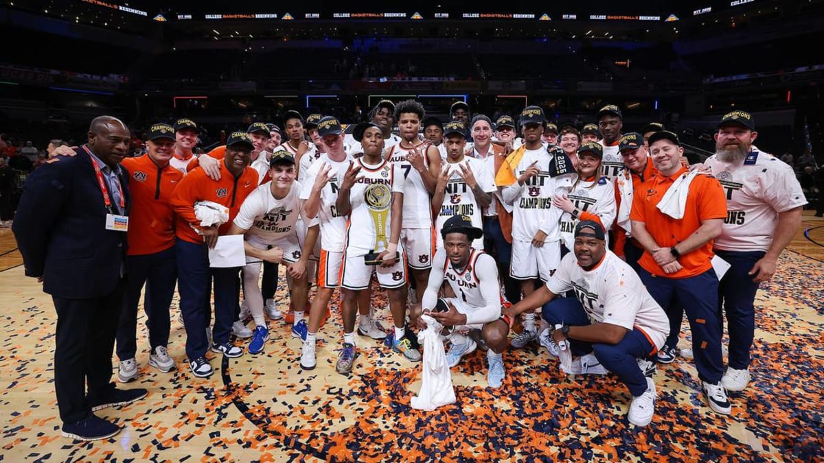 Auburn basketball player Kevin Overton celebrates winning the NIT championship with teammates