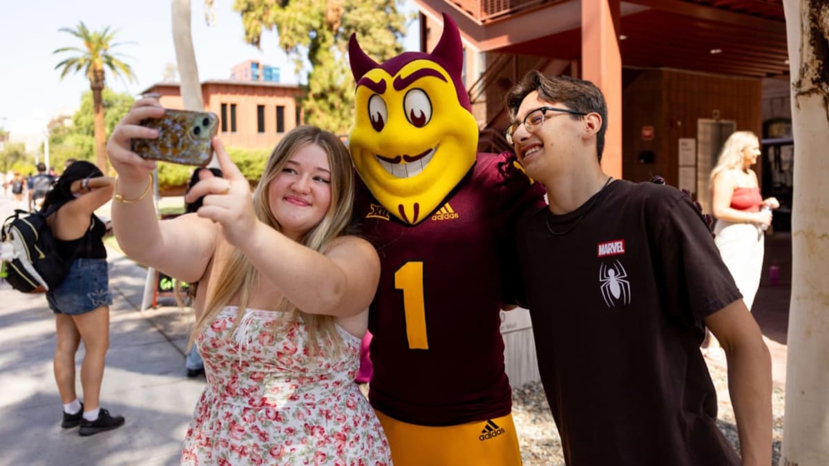 First-year ASU theater students Gabby Opulskas and Milo Buagarini pose with Sparky mascot on campus