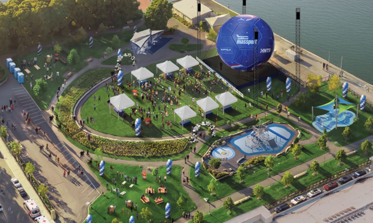 Giant 45-foot soccer ball installation towering over East Boston waterfront park with city skyline