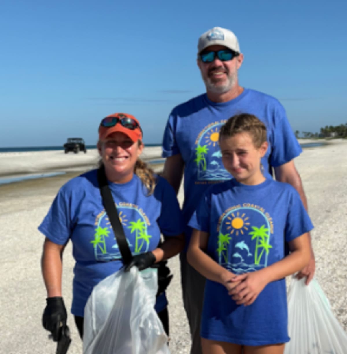 Diverse group of volunteers collecting trash and debris along sunny Florida beach coastline