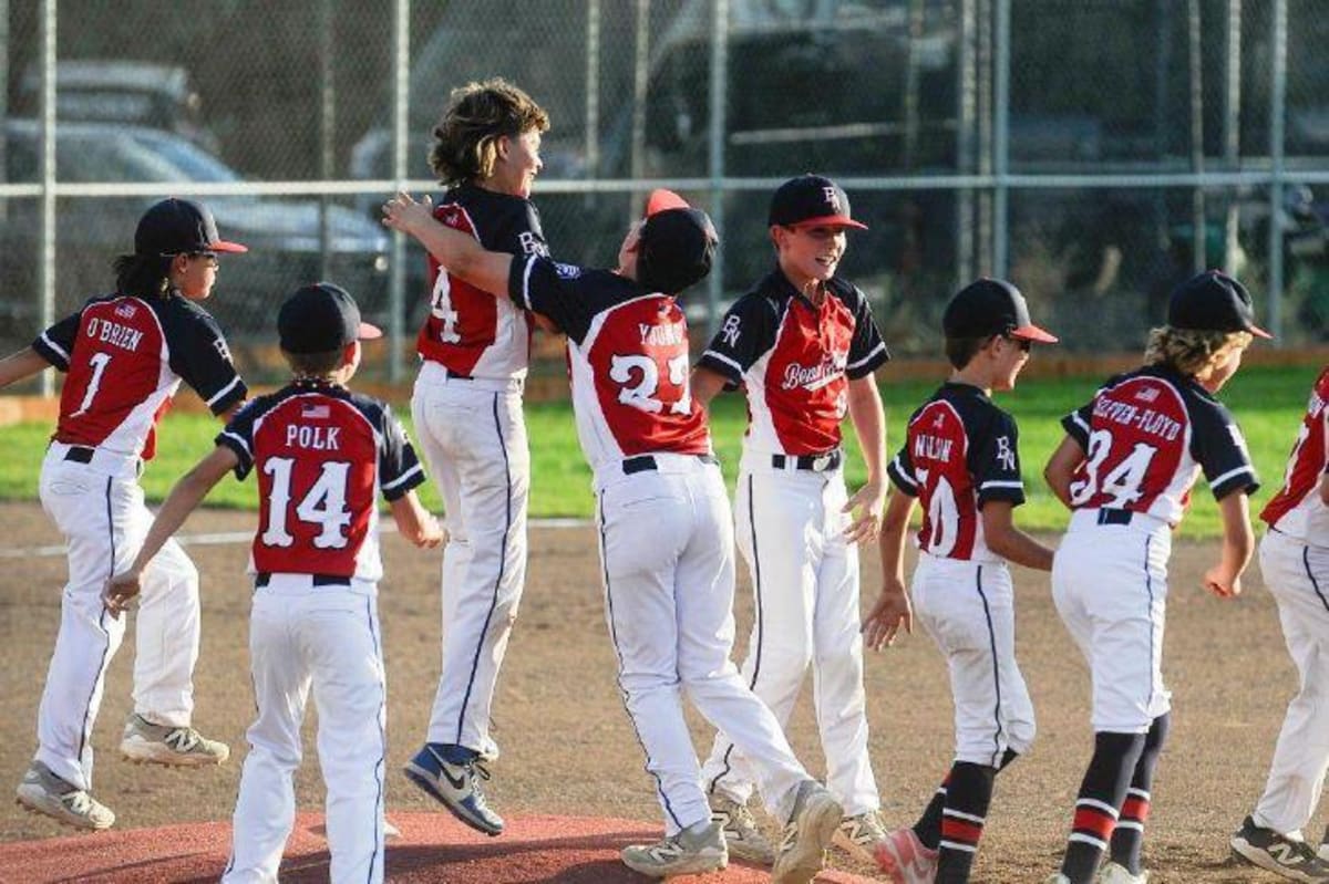 Bend North Little League 11U baseball team celebrating together after winning state championship