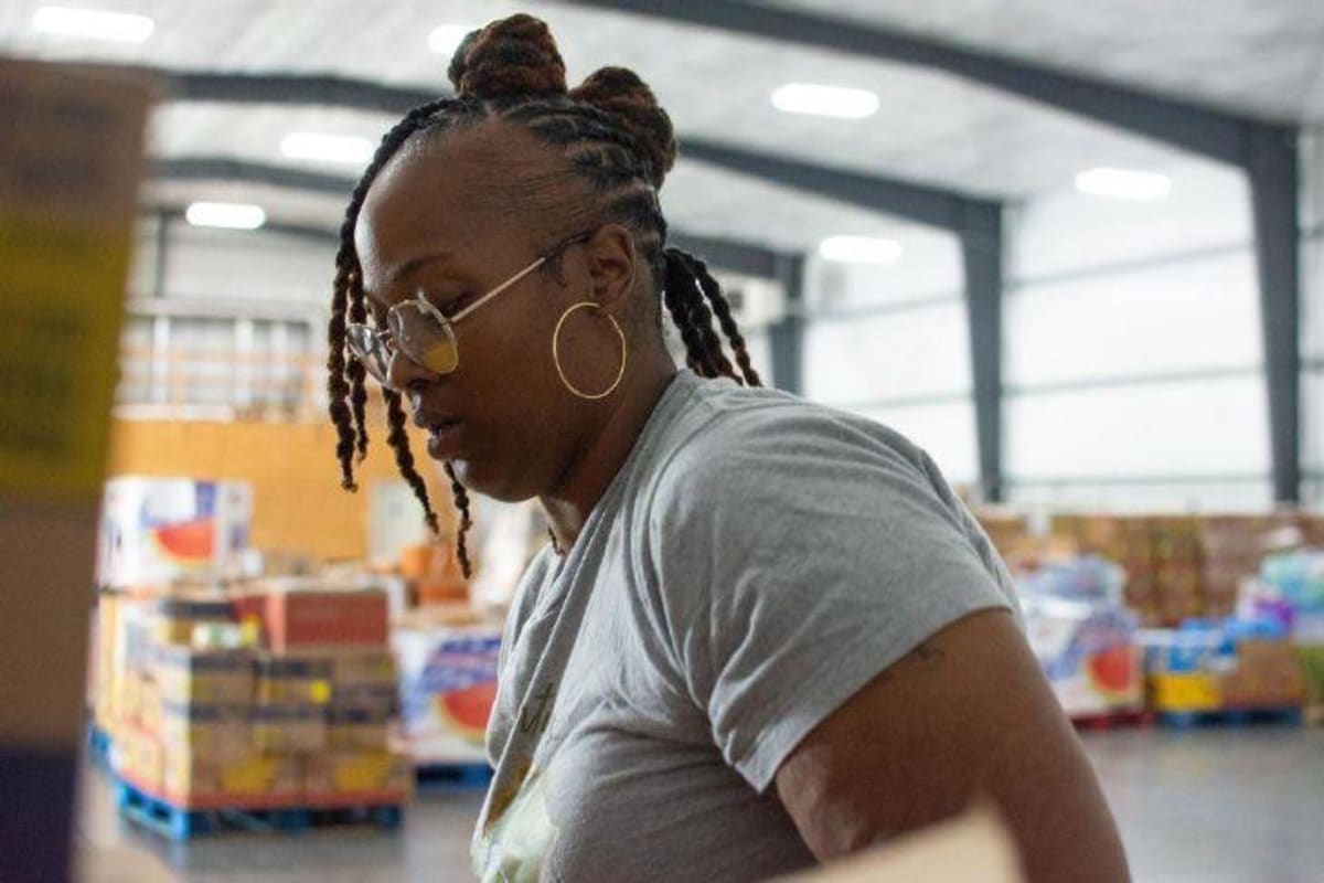 ** Warehouse workers organizing fresh rescued food into boxes at Kentucky food bank facility