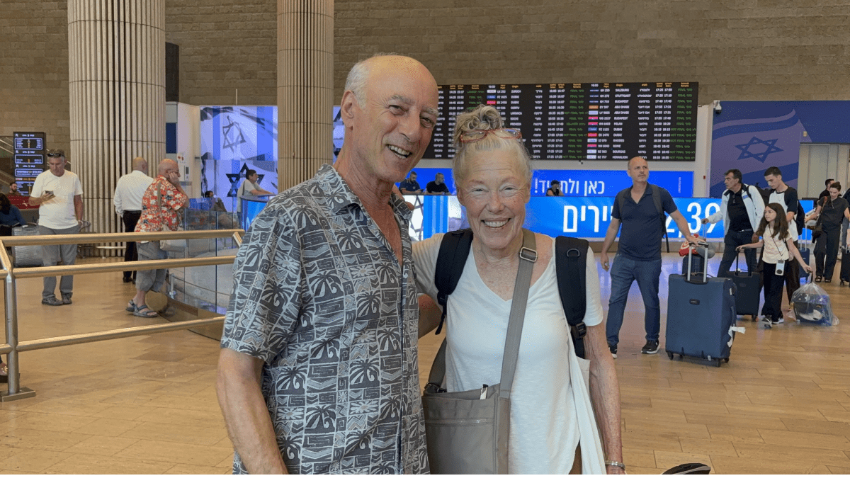 Two elderly cousins embracing emotionally at airport after meeting for first time in Israel