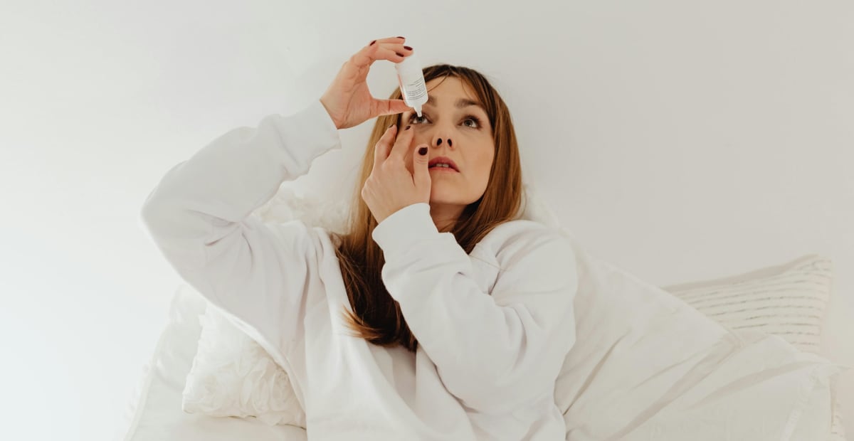 Close-up of person applying eye drops to treat dry eye irritation and discomfort