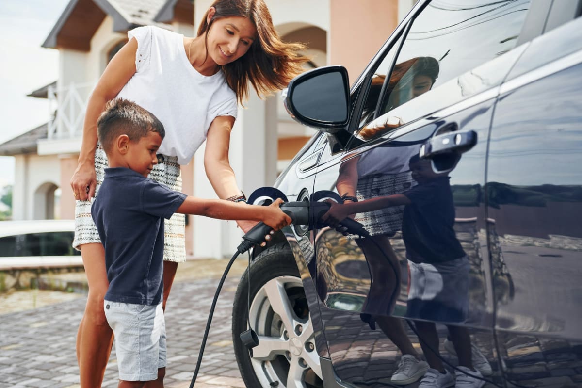 Electric vehicle charging at California dealership with instant rebate program signage displayed