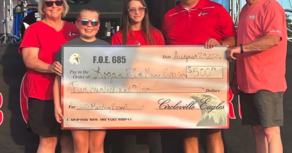 Eagles club members presenting oversized ceremonial check to community organization representatives