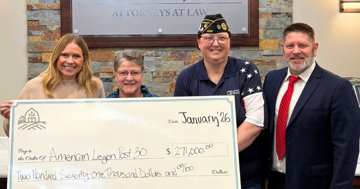 Community members and nonprofit representatives holding donation checks from Rasmussen farm sale proceeds