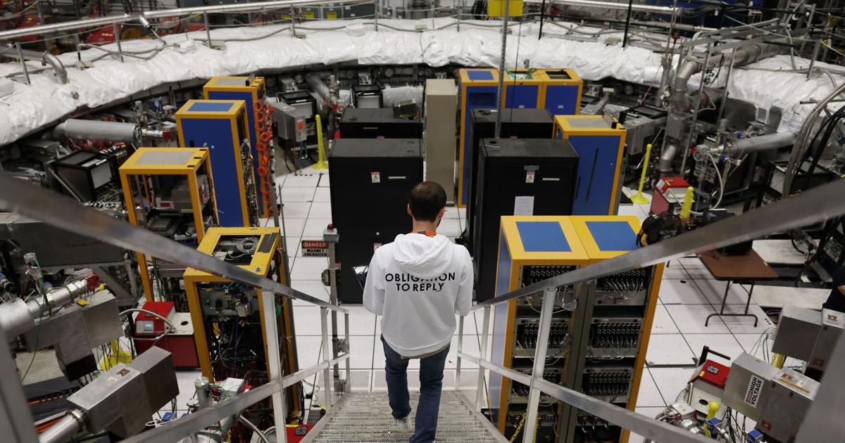 Researcher descending stairwell to Muon superconducting ring magnet at Fermilab experimental hall in Illinois