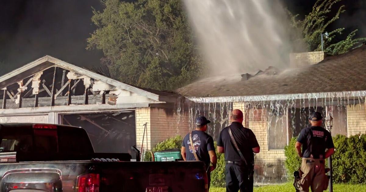 Firefighters battling flames at single-story residential house fire in early morning darkness