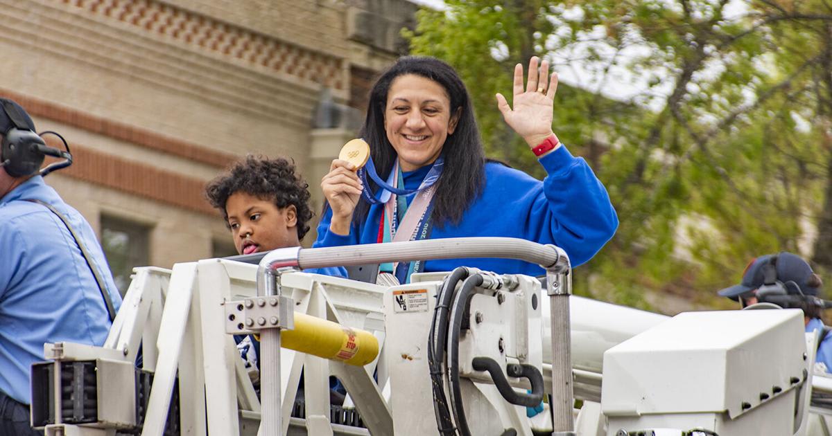 ** Elana Meyers Taylor waves from firetruck holding gold medal during New Braunfels parade celebration