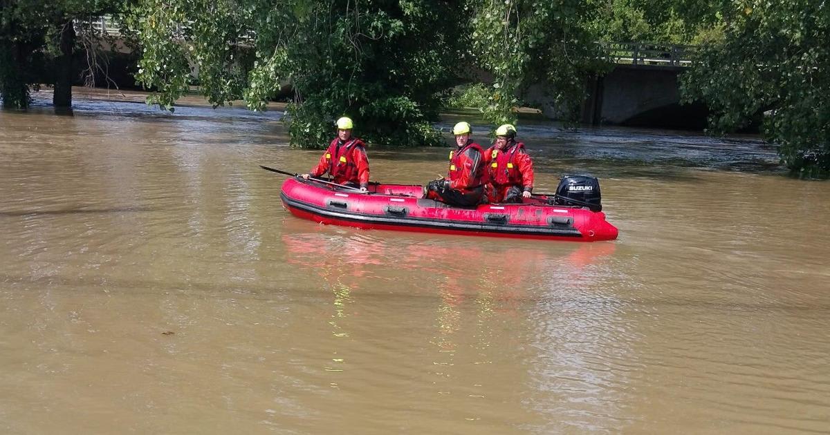 ** Anderson Fire Department rescue team navigating flood waters in boat near flooded restaurant