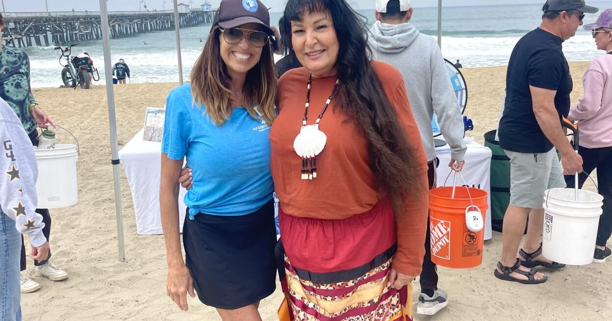 Acjachemen Tribal member Georgia Edmundson stands with Stand Up to Trash founder at beach cleanup event