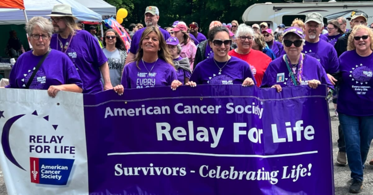 Cancer survivors and caregivers walking together during opening lap of Relay For Life event