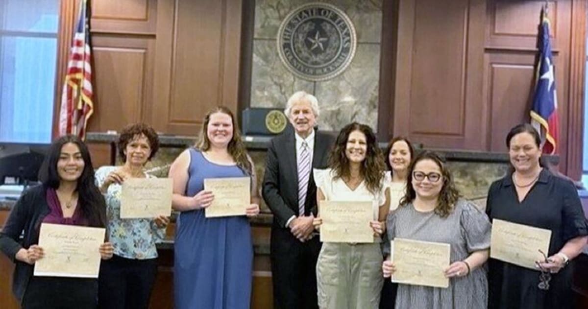 New CASA volunteers standing with Judge Brett Hall at Rockwall County Courthouse swearing in ceremony