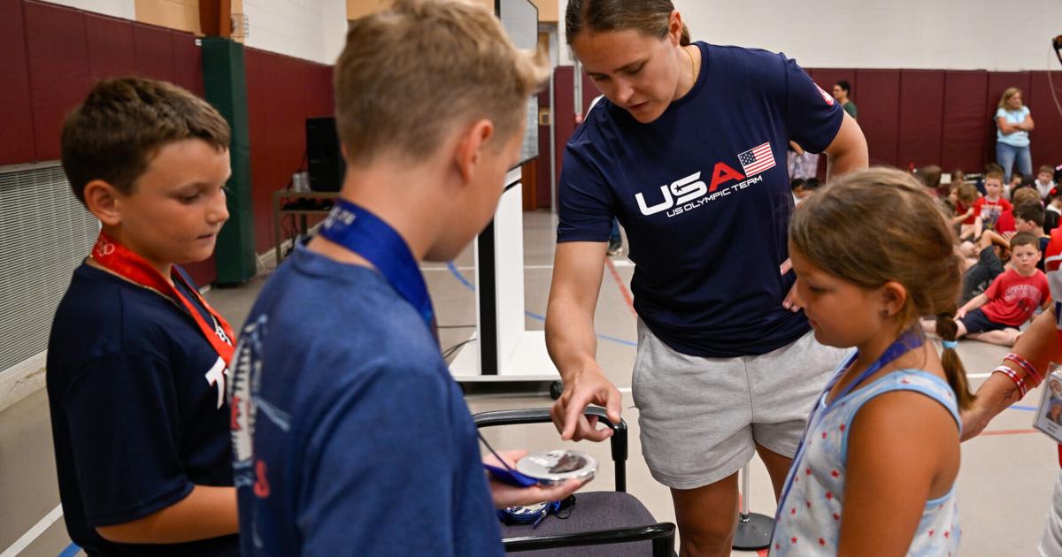 ** Olympic hockey player Alex Carpenter shows gold medal to elementary school students in Beverly classroom