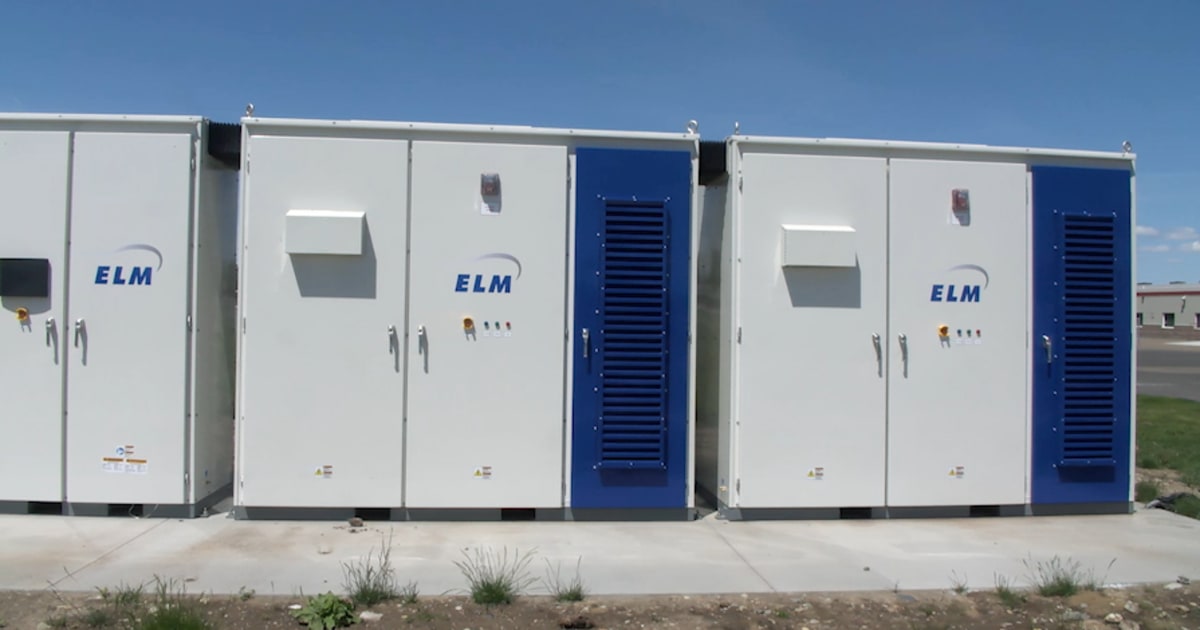 Large battery storage unit installed outside Valley View Elementary School with solar panels visible on building roof