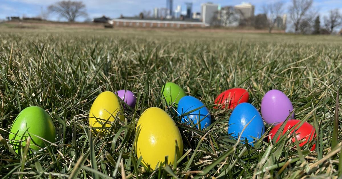 Colorful plastic Easter eggs scattered across green grass in community park setting