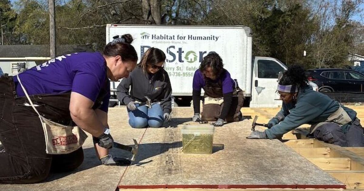 Four women volunteers hammer nails into floor of new Habitat for Humanity home in Goldsboro