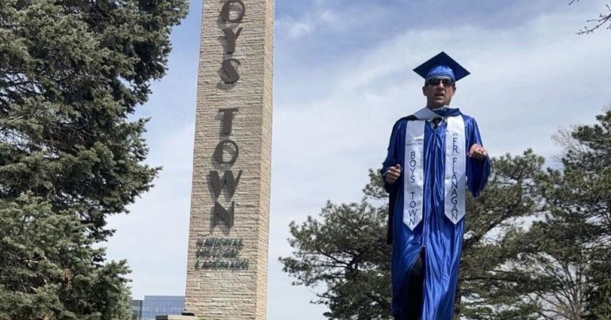 ** Jake Albanez in blue graduation cap and gown preparing for marathon world record attempt