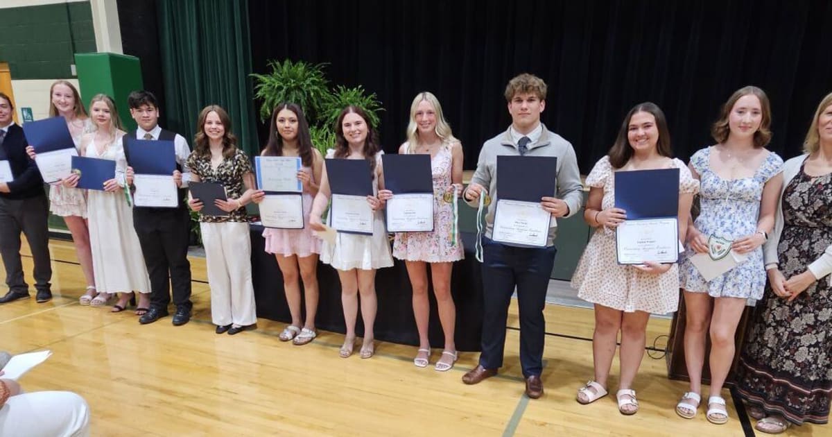 Green Lake School seniors holding National Honor Society cords and award certificates at scholarship ceremony