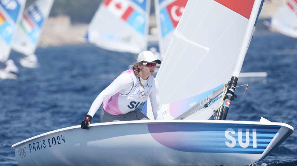 ** Swiss sailors racing high-speed catamaran on water during SailGP competition training
