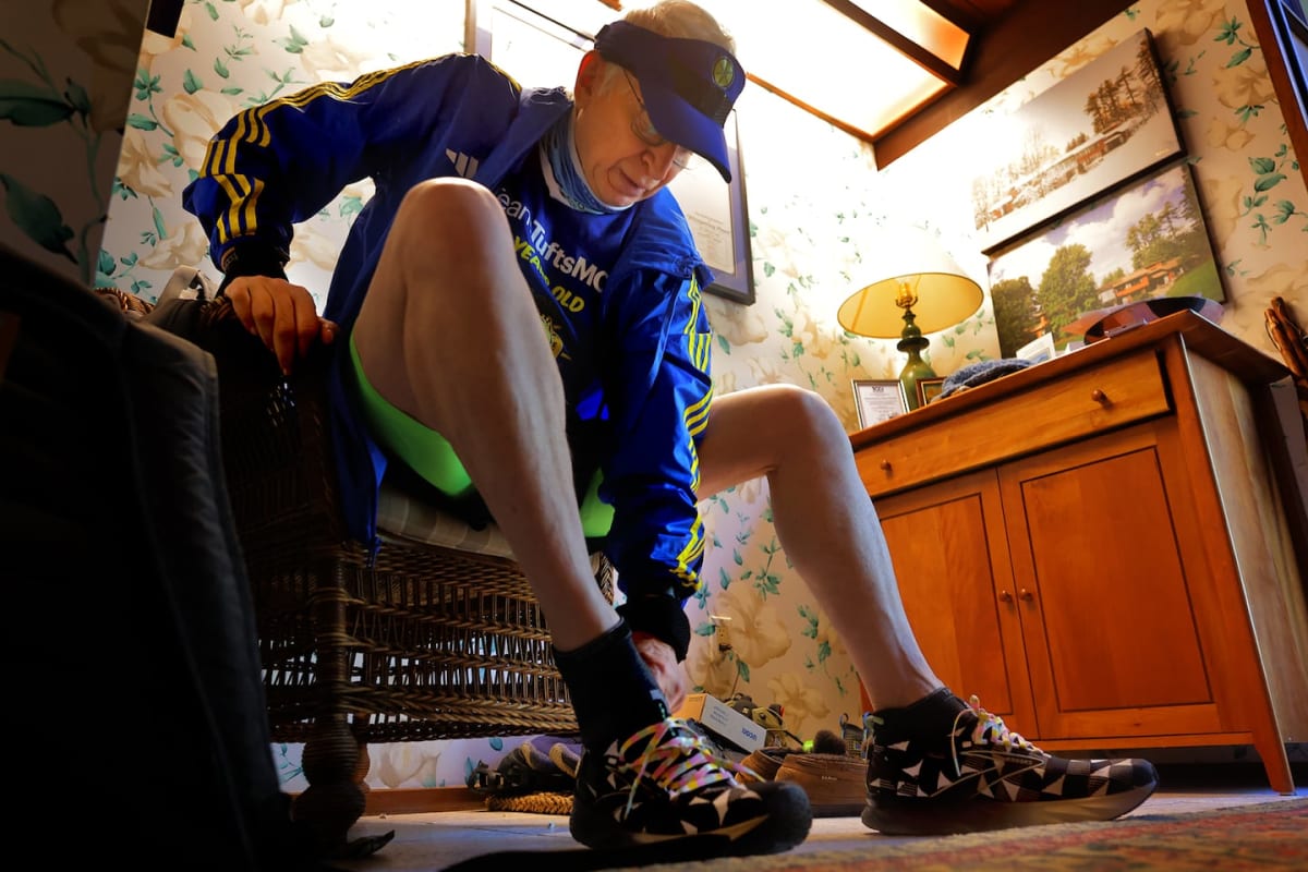 Elderly doctor in running gear jogging through residential neighborhood during training run