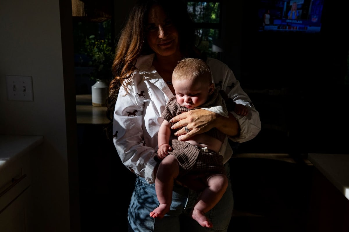 Jenilee Crowley smiling while holding her four-month-old son Archer at home