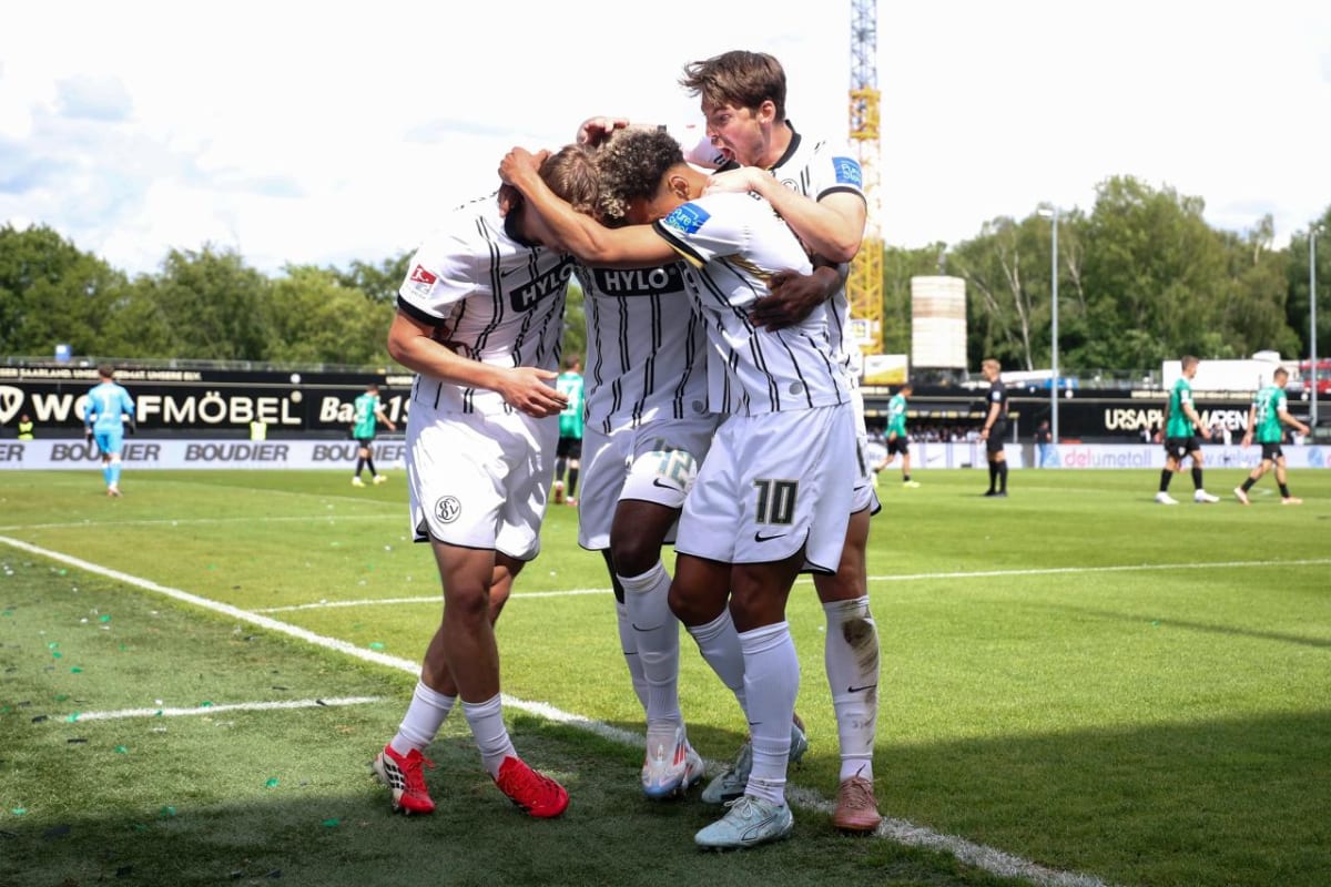 Elversberg football players celebrating historic promotion to German Bundesliga on stadium pitch