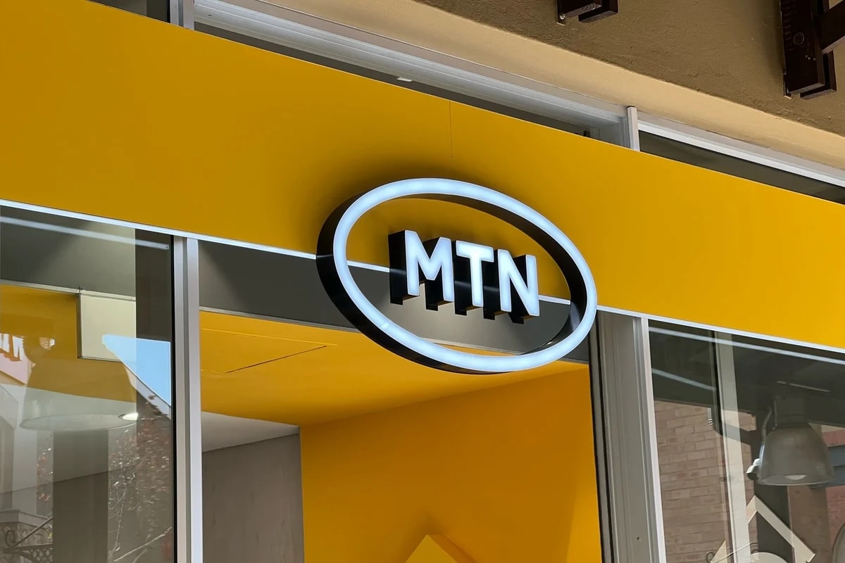 Person holding smartphone with MTN mobile network logo and airtime credit display