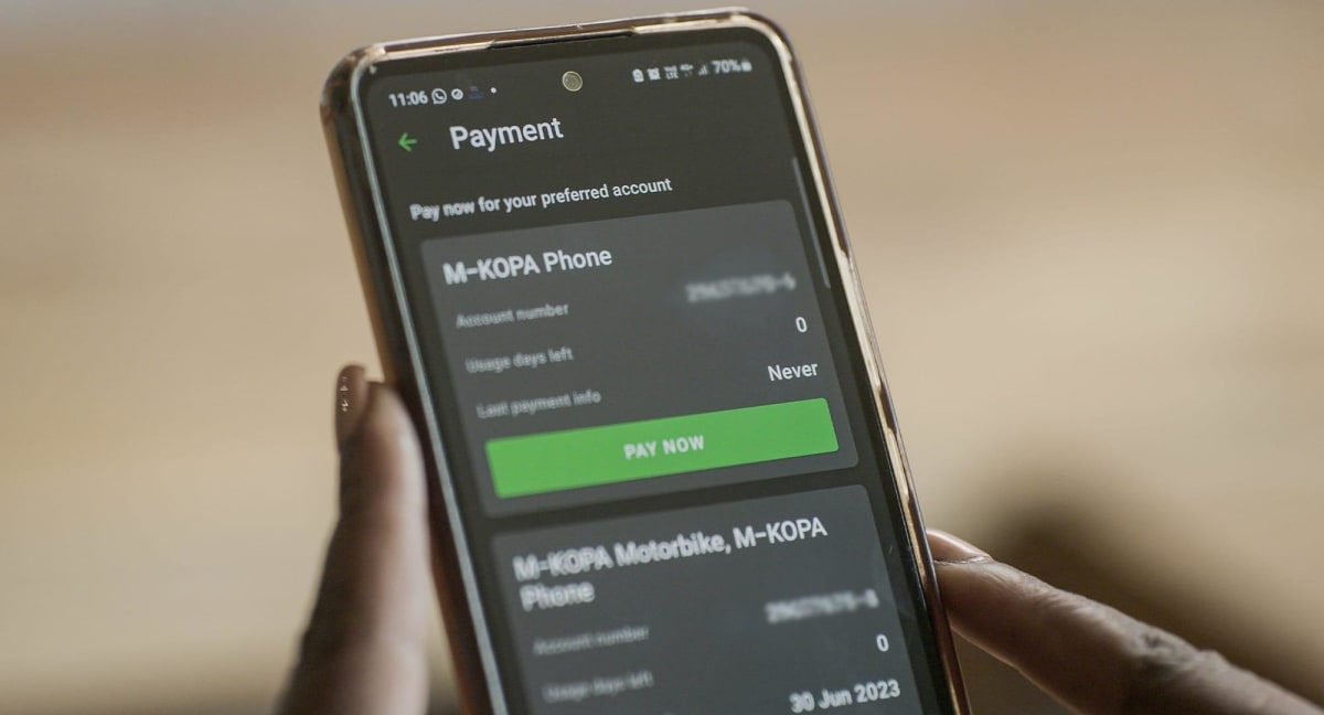 African person holding smartphone while making mobile payment for credit building