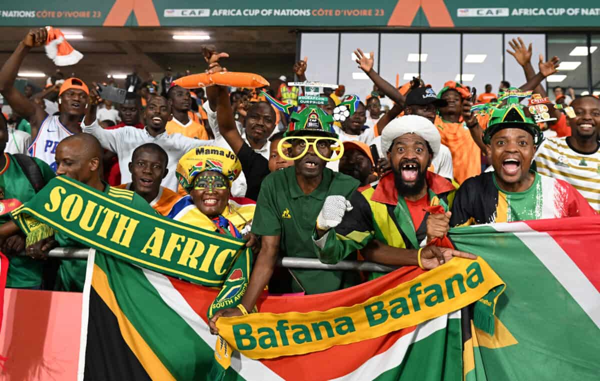 South African football fans celebrating with digital devices showing blockchain fan token interface