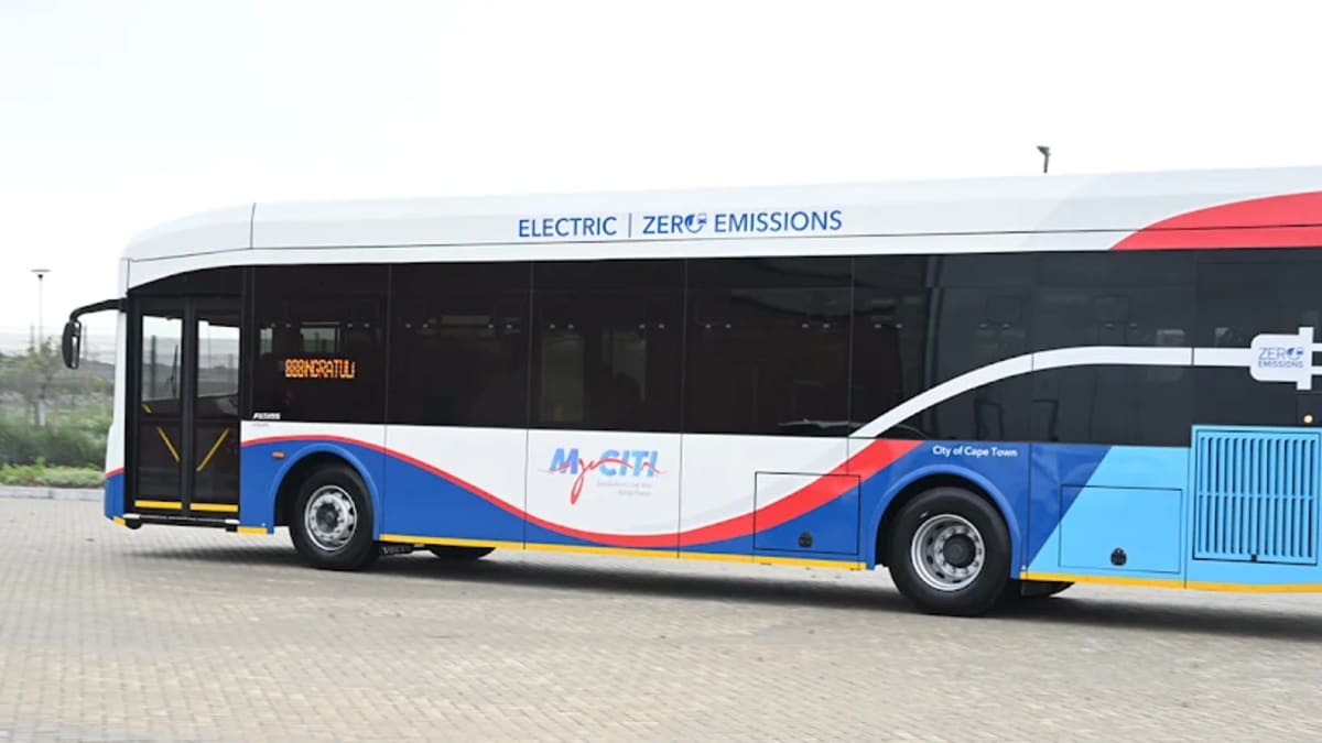 ** Modern white electric bus on Cape Town street with passengers waiting at station