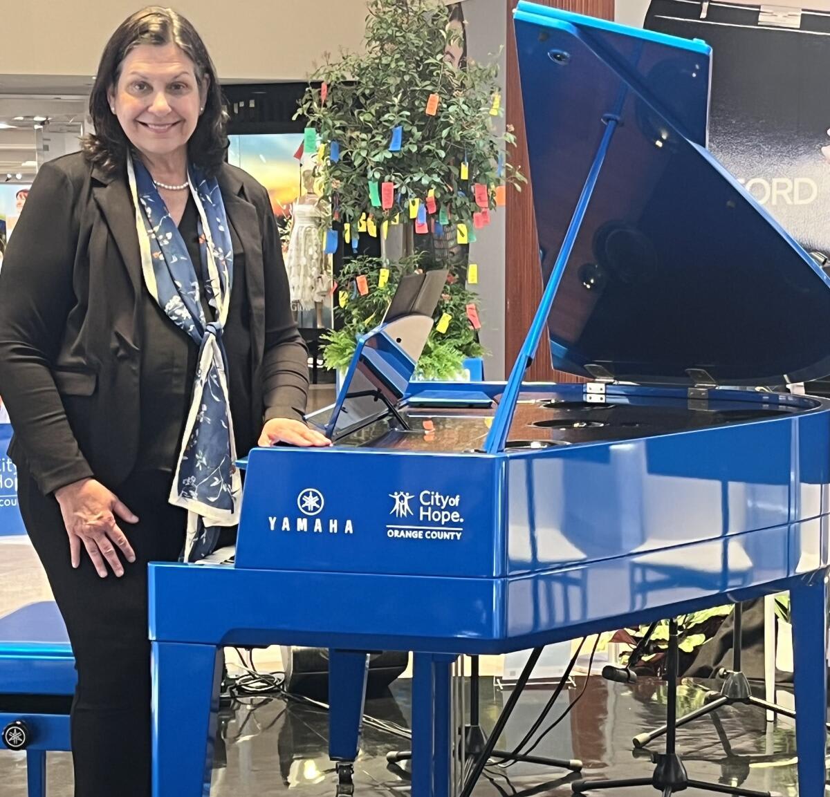 Blue grand piano at South Coast Plaza with wishing trees for cancer survivor encouragement messages