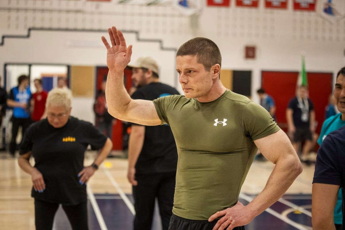 Athlete Chris Stipdonk in push-up position hopping on knuckles during Arctic Winter Games competition