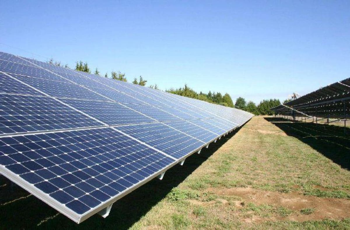 ** Solar panel arrays stretching across Eastern Washington agricultural land under blue sky