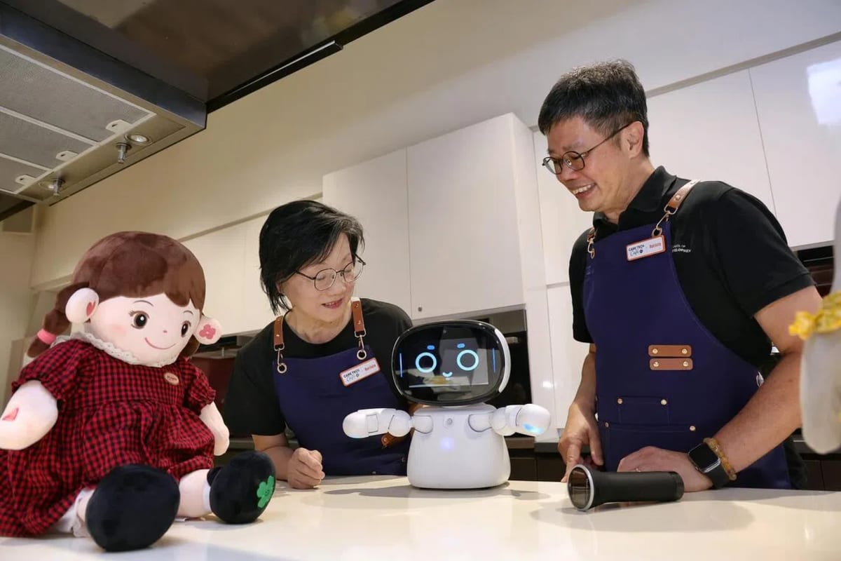 Senior resident trying out health monitoring technology with university professor at community café