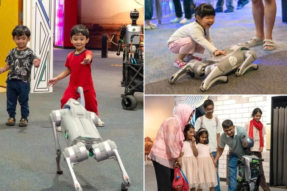 Children gather around colorful robots during hands-on building activities at Singapore Science Centre