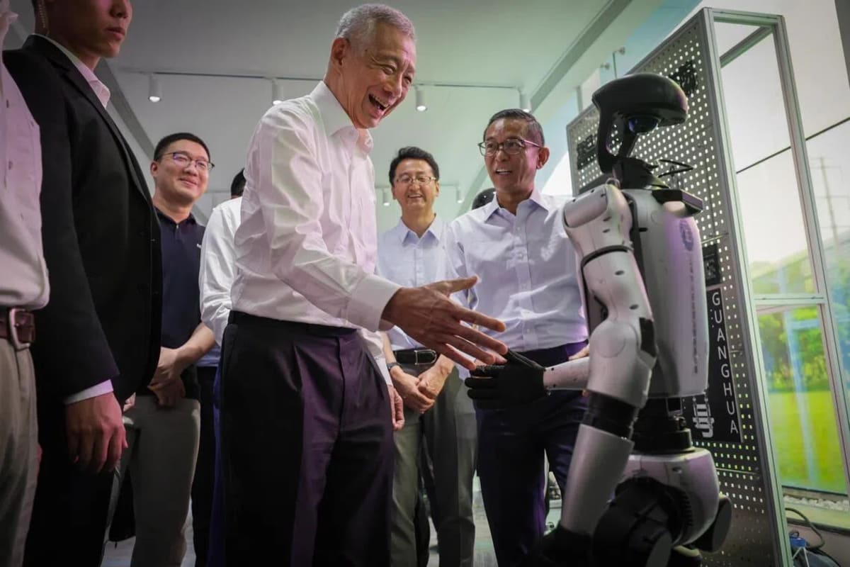 Senior Minister Lee Hsien Loong shaking hands with advanced humanoid robot at Shanghai innovation center