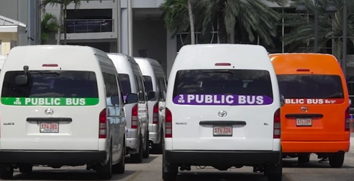 Bus driver Nigel Hudson standing beside his public bus in the Cayman Islands