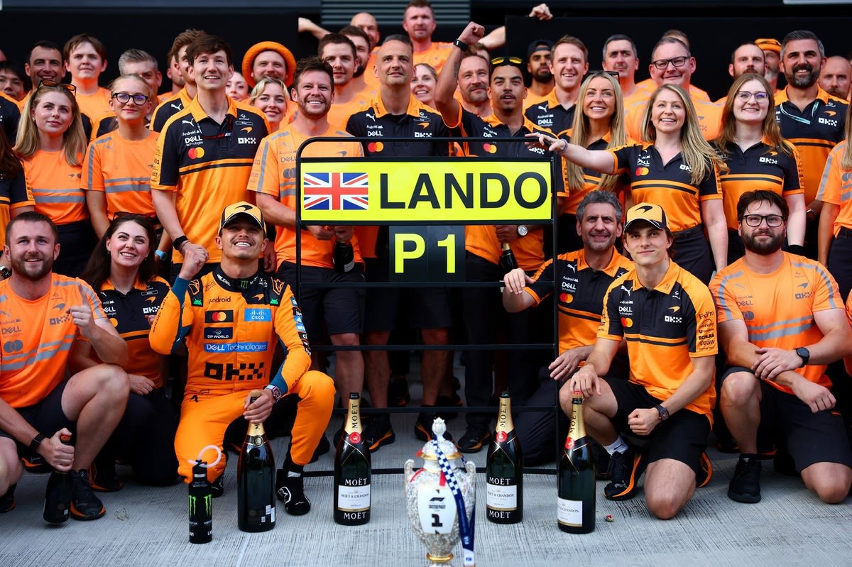 ** Lando Norris celebrating his Hungarian Grand Prix victory at McLaren in his racing suit