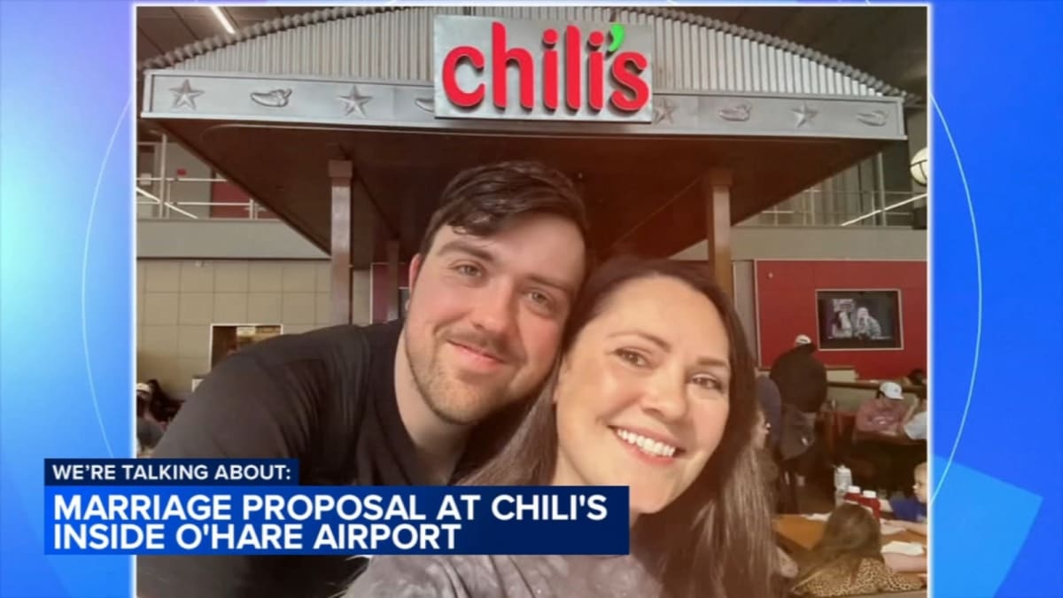 Couple embracing at airport Chili's restaurant after romantic proposal at O'Hare Terminal