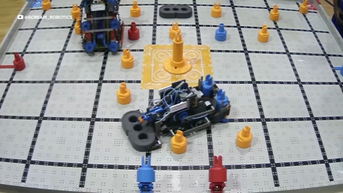 Four middle school students standing with their competition robot after winning state robotics championship