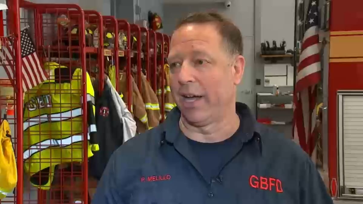 Fire chief Robert Melillo standing beside his SUV on highway in Westchester County New York