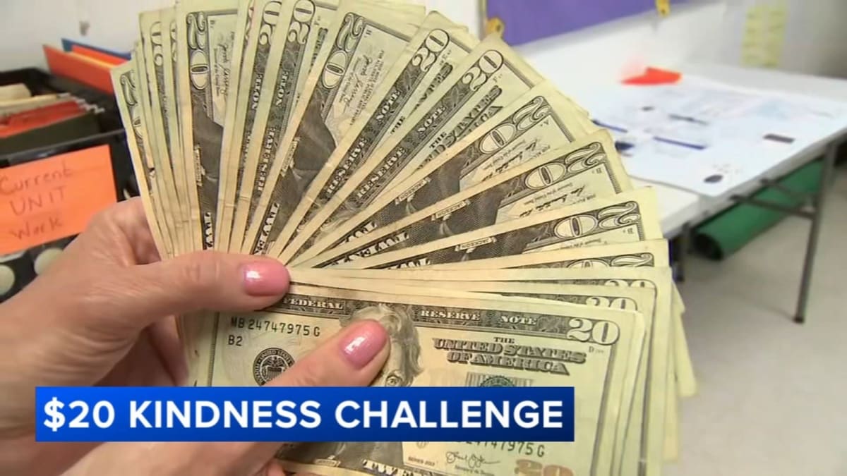 High school students holding twenty dollar bills while learning about kindness challenge program