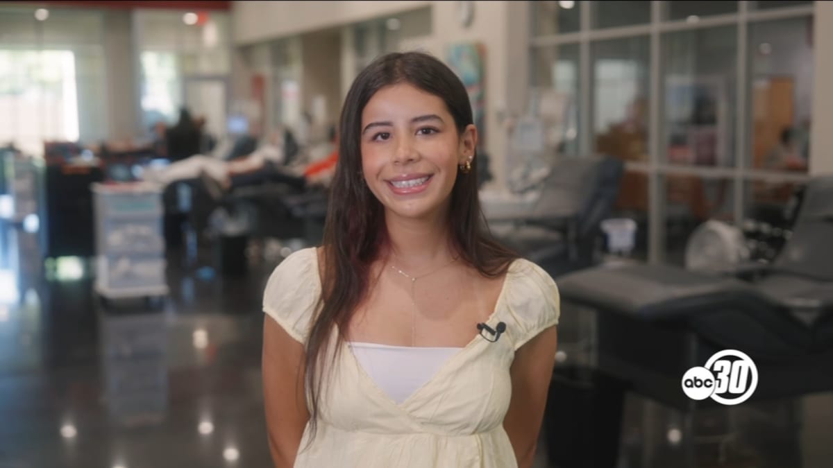 Smiling teenage girl Ariya Behrens standing at blood donation center promoting summer drive